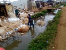Maganda washing the plastic bags in a stream of water