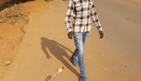 a picture of a young man whom I pictured throwing a plastic bottle on the road